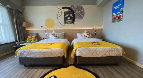 two beds in a hotel room with yellow beds at Imin Hotel in Huadu
