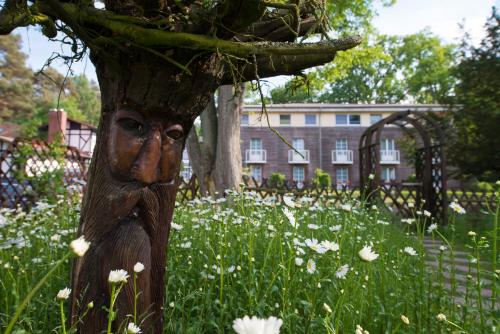 a tree with a face on it in a field of flowers at Best Western Plus Ostseehotel Waldschloesschen in Prerow