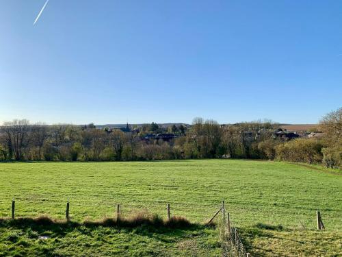 a large green field with a fence in the foreground at Maison Horizon in Ocquier
