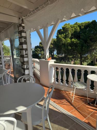 a porch with tables and chairs on a balcony at Diaporos Hotel in Vourvourou