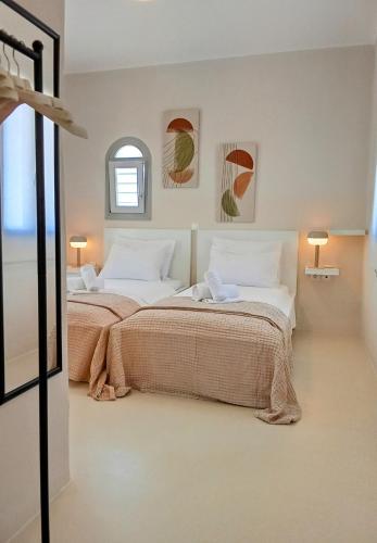 two beds in a white room with two lamps at Aktaea, Seaside Residence in Santa Maria