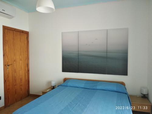 1 dormitorio con 1 cama y una gran pintura en la pared en De Gama 2, en Marina di Ragusa