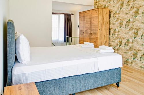 a bedroom with a large bed and a wooden cabinet at Villa Maldives, right on sea in center of Fethiye in Fethiye