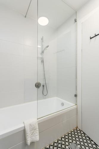 a white bathroom with a shower and a tub at Unique Masterpiece in the Heart of Jerusalem in Jerusalem