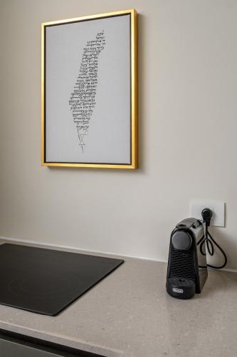 a black phone sitting on a counter with a picture on the wall at Unique Masterpiece in the Heart of Jerusalem in Jerusalem