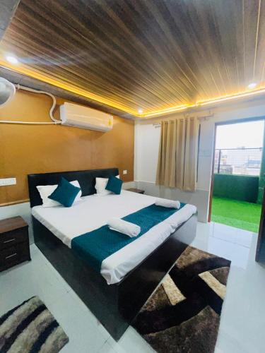 a bedroom with a large bed with blue pillows at The Ghat House in Varanasi