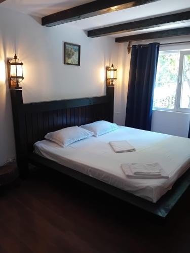 a bedroom with a bed with two pillows and a window at Magic Garden Villa in Vama Veche
