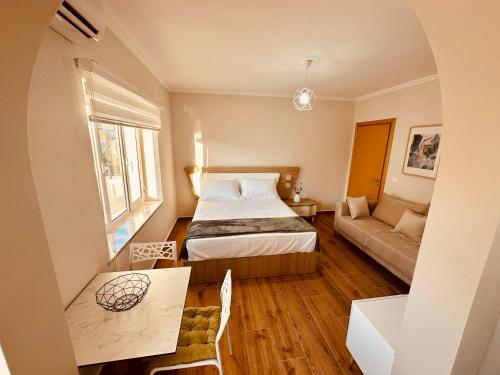 a small bedroom with a bed and a couch at Holiday Home Lezha 2 in Lezhë