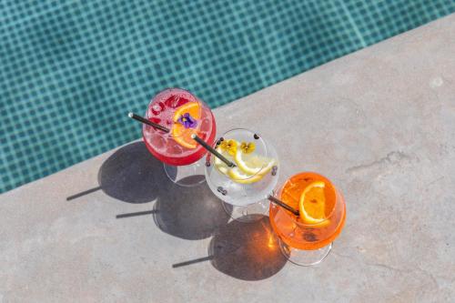 two cocktails sitting next to a swimming pool at Grand Hotel Du Golfe - Spa & Restaurant in Collioure
