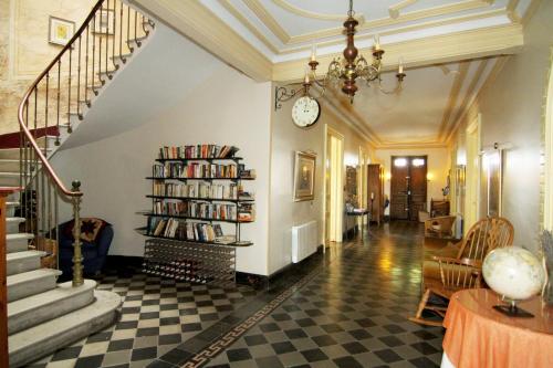 un salon avec un escalier et une horloge sur le mur dans l'établissement Les Volets Bleus, à Sallèles-dʼAude