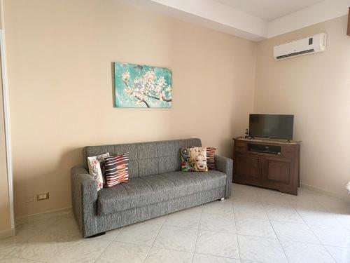 Una sala de estar con un sofá y un televisor. en LE CASE DI CICCIO - Appartamenti in Centro, en Mazara del Vallo