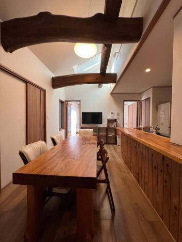 a dining room with a table and a kitchen at moksa House ヒリゾ浜まで車で10分ゆったりNetflixコンビニとスーパーは7分 in Kanō