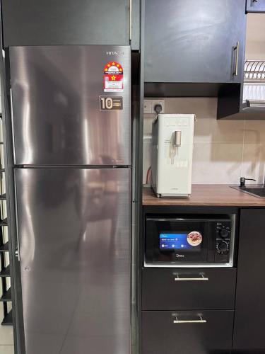a kitchen with a stainless steel refrigerator in a kitchen at Bali Residence by D'RZ Muslim Seaview Homestay in Melaka