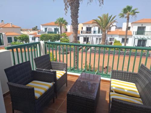 a balcony with wicker chairs and a table with a view at Las Adelfas 2 in San Miguel de Abona