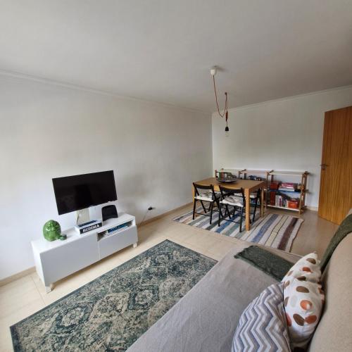 a living room with a tv and a dining room table at Apartamento do Paço do Lumiar in Lisbon