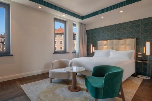 a bedroom with a bed and a table and a chair at Hilton Turin Centre in Turin