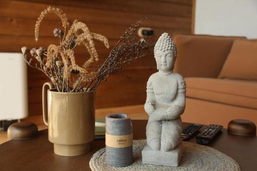 a table with a statue and a vase with a plant at Hover Boutique Hotel in Dilijan