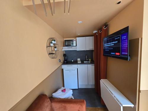 una piccola cucina con divano e una TV in camera di 1G- Studio tout equipé proche de la scène musicale a Issy-les-Moulineaux