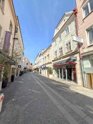 an empty street in a city with buildings at Danube Holiday Rooms in Krems an der Donau