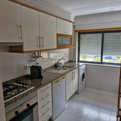 a kitchen with white cabinets and a sink at Apartamento do Paço do Lumiar in Lisbon