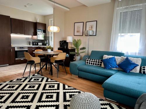 バラトンセメッシュにあるRemora Apartman Balatonszemesの青いソファとテーブルのあるリビングルーム