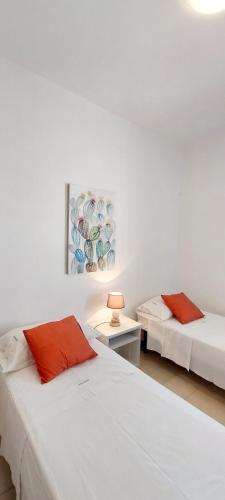 a bedroom with two beds and a table with a lamp at TORRE LAPILLO Fronte Mare in Centro con parcheggio coperto in Torre Lapillo