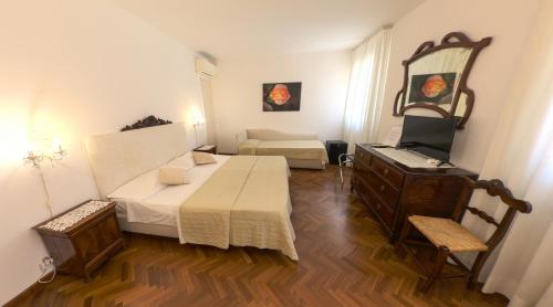 a room with a bed and a dresser in it at Ai Giardini di San Vitale in Ravenna