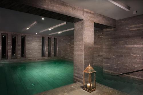 a swimming pool with green water in a building at Esperos Palace Luxury & Spa Hotel in Kastoria