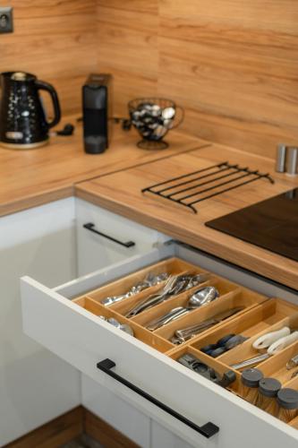 a kitchen with a drawer filled with cooking utensils at Chaty ForRest in Valča