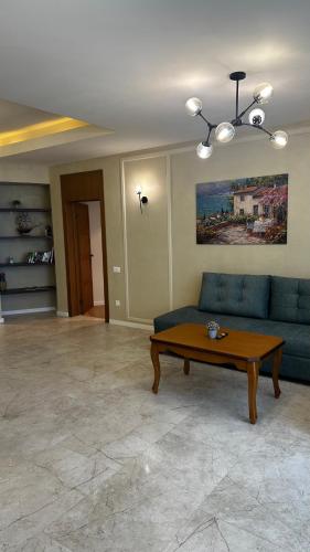 a living room with a blue couch and a table at Sea Breeze Resort, Beachfront apartment with a balcony and sea view in Nardaran
