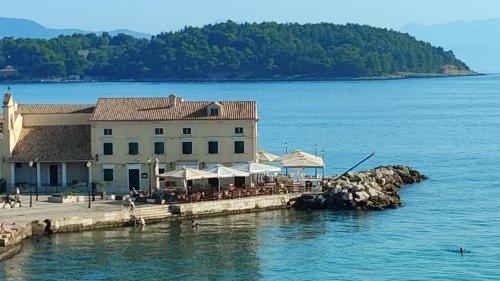 a restaurant on a dock in the water next to the ocean at Casa Stratigos in Corfu