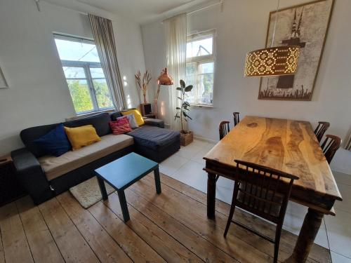 a living room with a table and a couch at Hilltop view - 2 bedroom house with garden bbq - private parking - 12min to Uzupis anytime in Vilnius