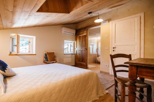 a bedroom with a bed and a table and a desk at La Contrà Valpolicella in Fumane