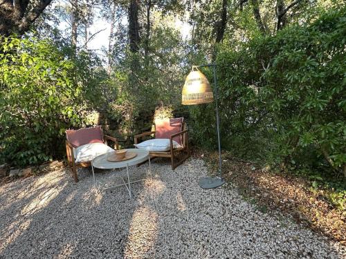 a couple of chairs and a table and a lamp at Le Cabanon du Lac in La Roquebrussanne