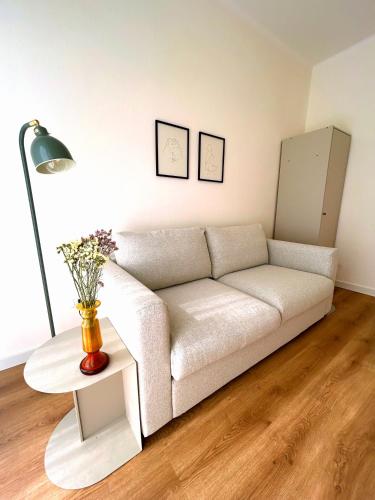 een woonkamer met een witte bank en een tafel bij Ponente Blue Appartamenti, 7 in Arma di Taggia