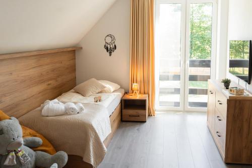 a bedroom with a bed with two teddy bears on it at Chaty ForRest in Valča
