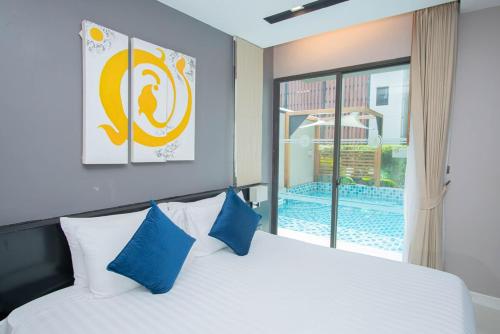 a bedroom with a bed with blue pillows and a window at Beachfront Family Pool 2 Bed Room Patong Phuket in Patong Beach