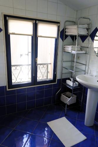 La salle de bains est pourvue de 2 fenêtres et d'un lavabo. dans l'établissement Les chambres de la Dombes, à Pizay