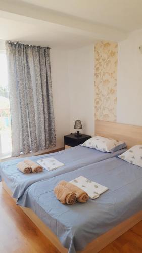 two beds in a bedroom with towels on them at Guest House Bogat-Beden in Ravda