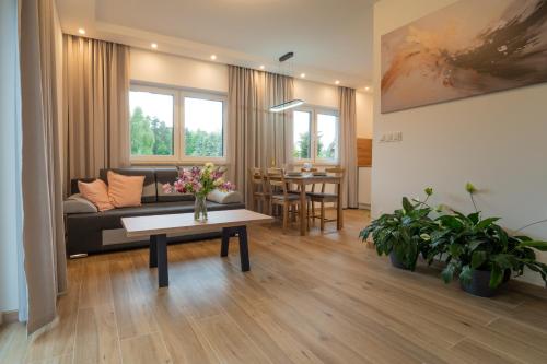 a living room with a couch and a table at Lavender domek na Kaszubach - Przechlewo in Przechlewo
