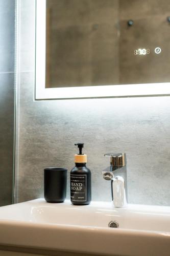 a bottle of soap sitting on top of a sink at Chaty ForRest in Valča