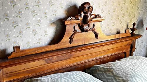 a wooden headboard of a bed with a spider on it at 'Les Comètes' B&B in La Caujonnet
