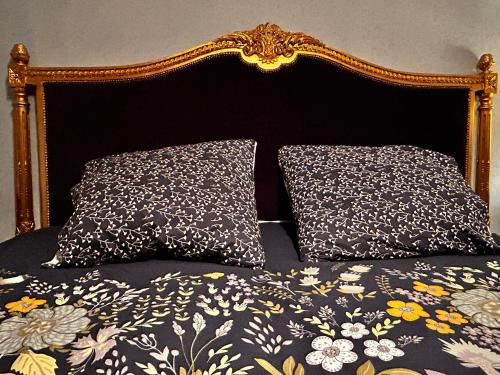 a bed with two pillows on top of it at 'Les Comètes' B&B in La Caujonnet