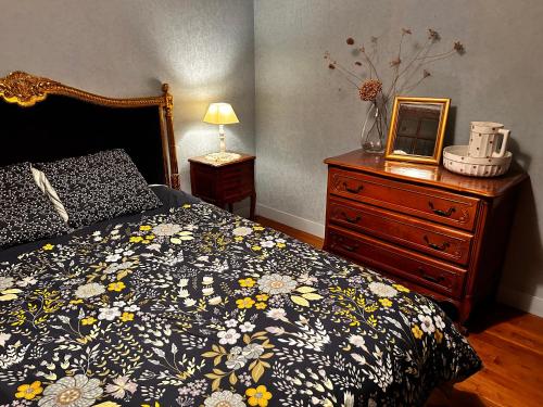 a bedroom with a bed and a dresser at 'Les Comètes' B&B in La Caujonnet