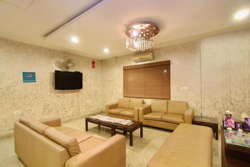 バンガロールにあるHotel Amshi Internationalのソファ、テーブル、テレビが備わる待合室