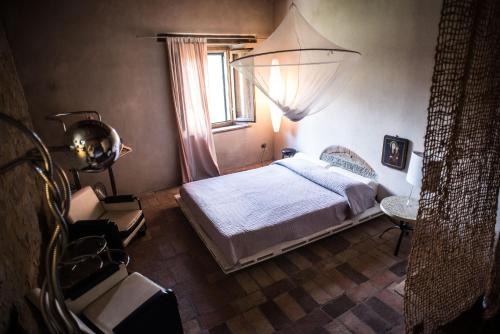 a bedroom with a bed and a window at Morelliana4Rooms in Scansano