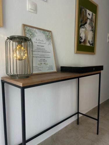 a table with a sign and a lamp on it at The mint in Politiká