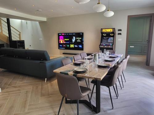 a dining room with a table with chairs and a couch at Séjour d'Exception - Villa 4 Suites Vue Cascade in Gavarnie