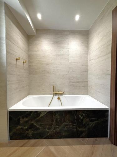a large bath tub in a bathroom with a black counter at Séjour d'Exception - Villa 4 Suites Vue Cascade in Gavarnie