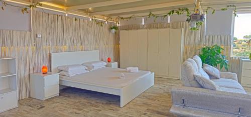 a room with a bed and two chairs and a couch at Satori Studio - open plan seaviews private terrace & shared pool in Il-Pergla